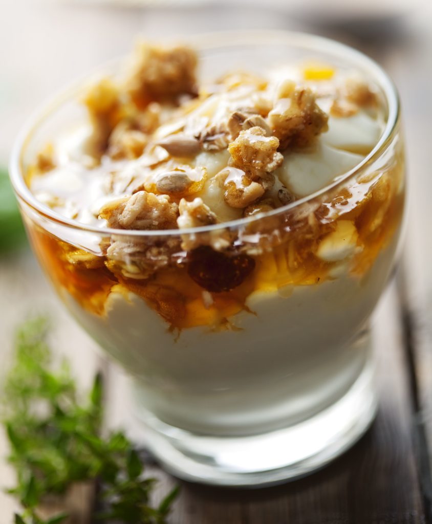 close up of greek yogurt with golden wild honey and musli