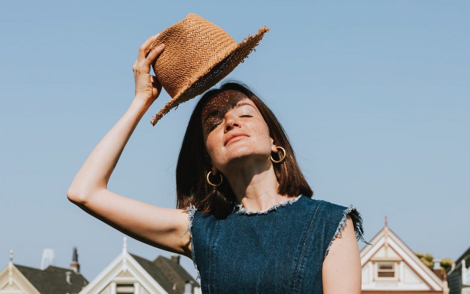ženska s klobukom na soncu