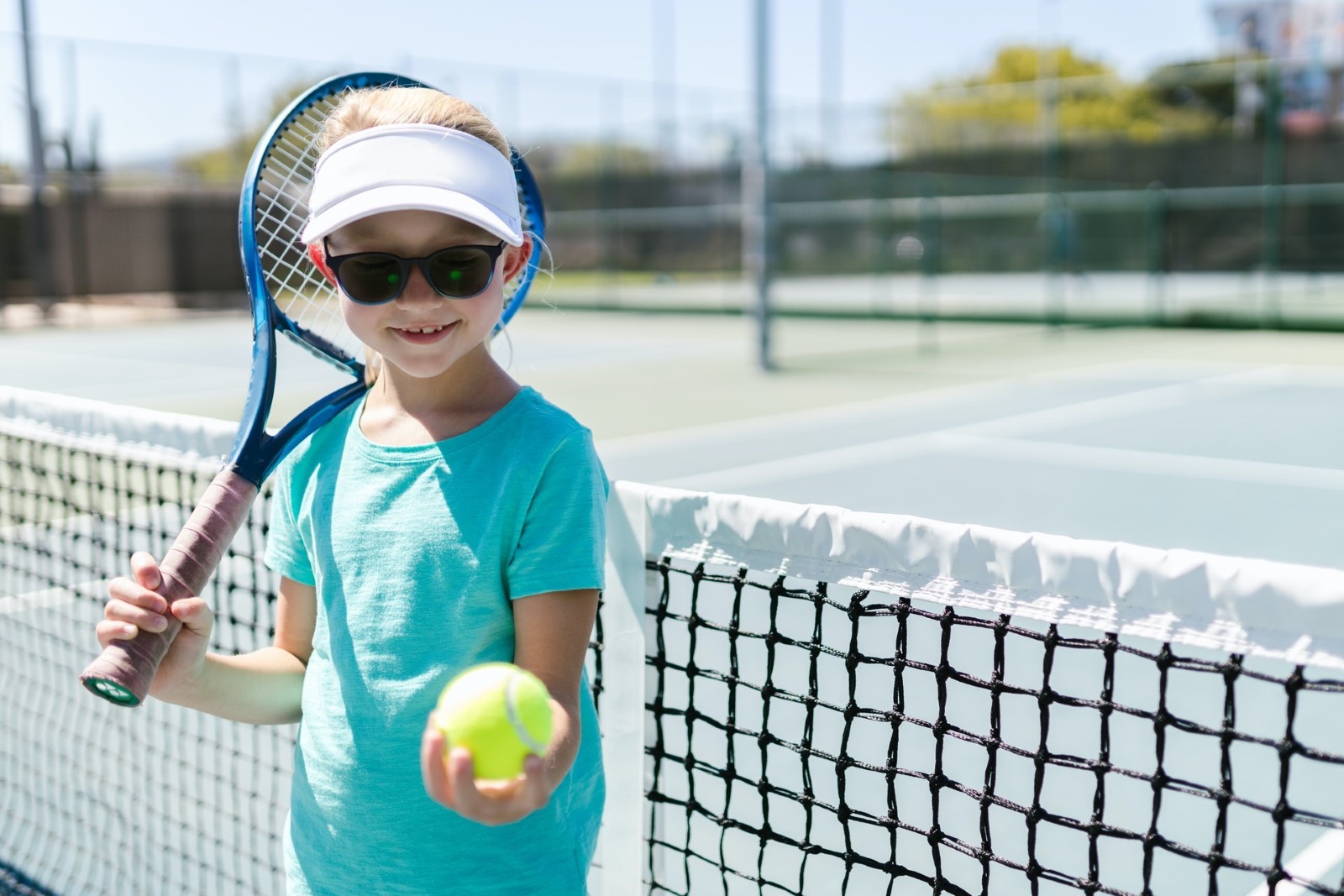 A child holding a tennis racket  Description automatically generated with medium confidence