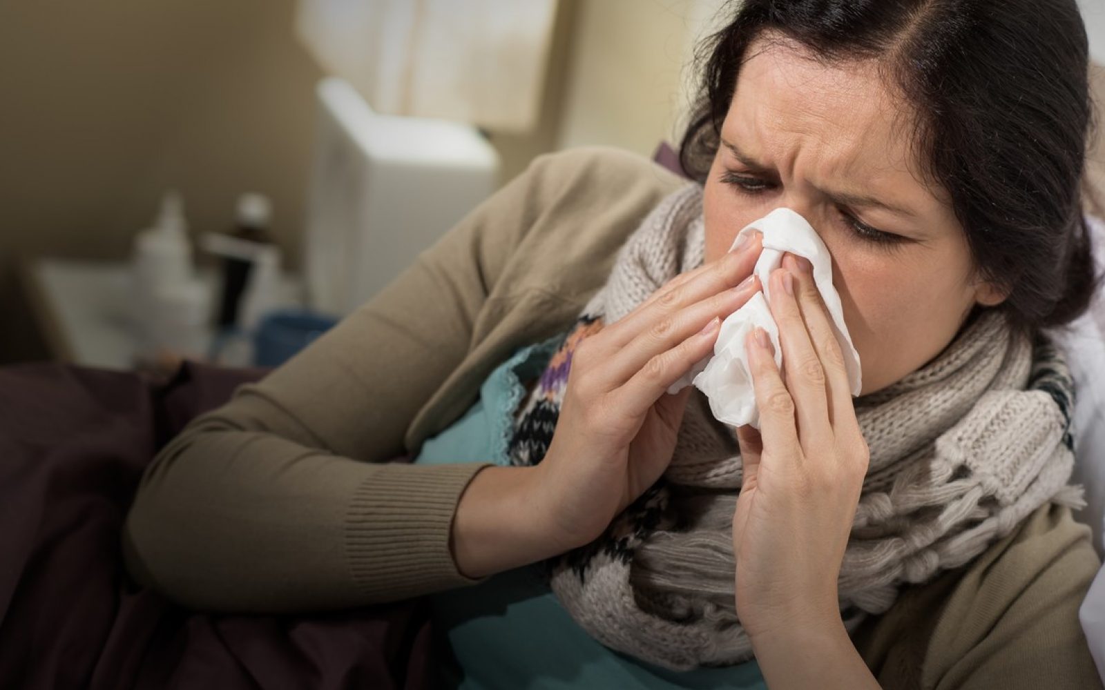 Prehlajena ženska se briše nos