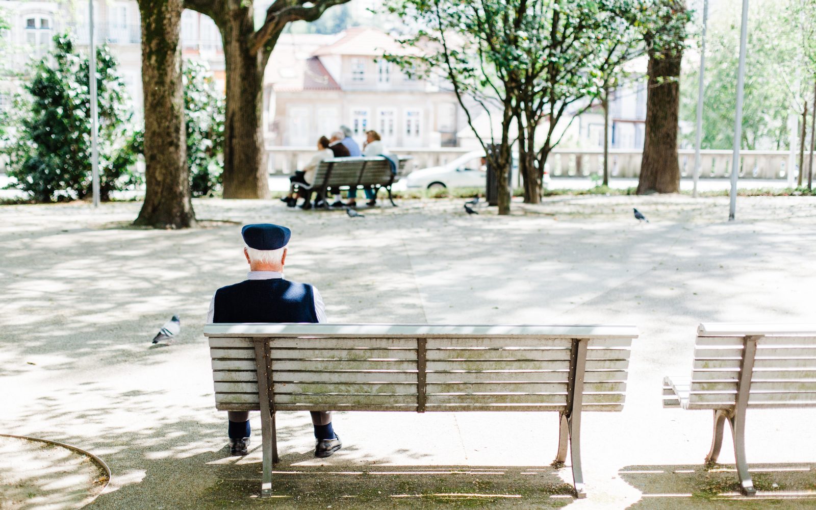Starostnik sedi na klopci v parku