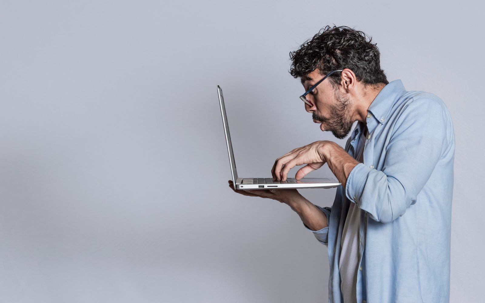 Presenečen moški gleda v računalnik