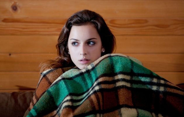 ženska v postelji strah pokrita z odejo