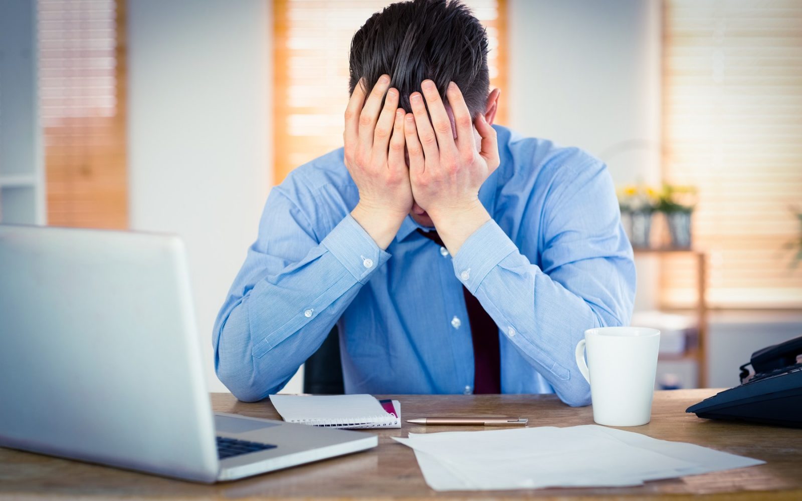 Moški na delovnem mestu obupan zaradi preveč dela