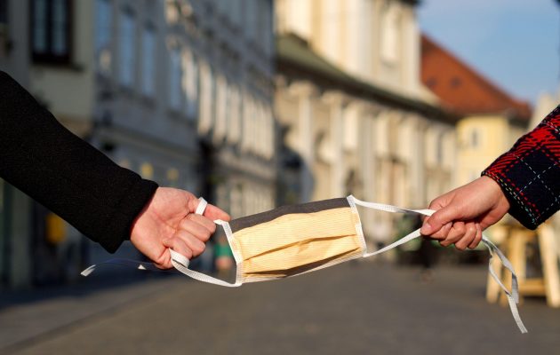 Dve roki držita masko, simbolično nakazujeta na onesnažen zrak v Ljubljani