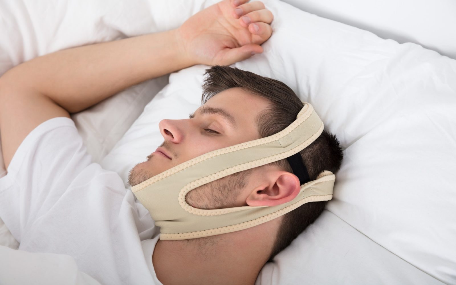 Moški uporablja trak proti smrčanju za boljše dihanje skozi nos.