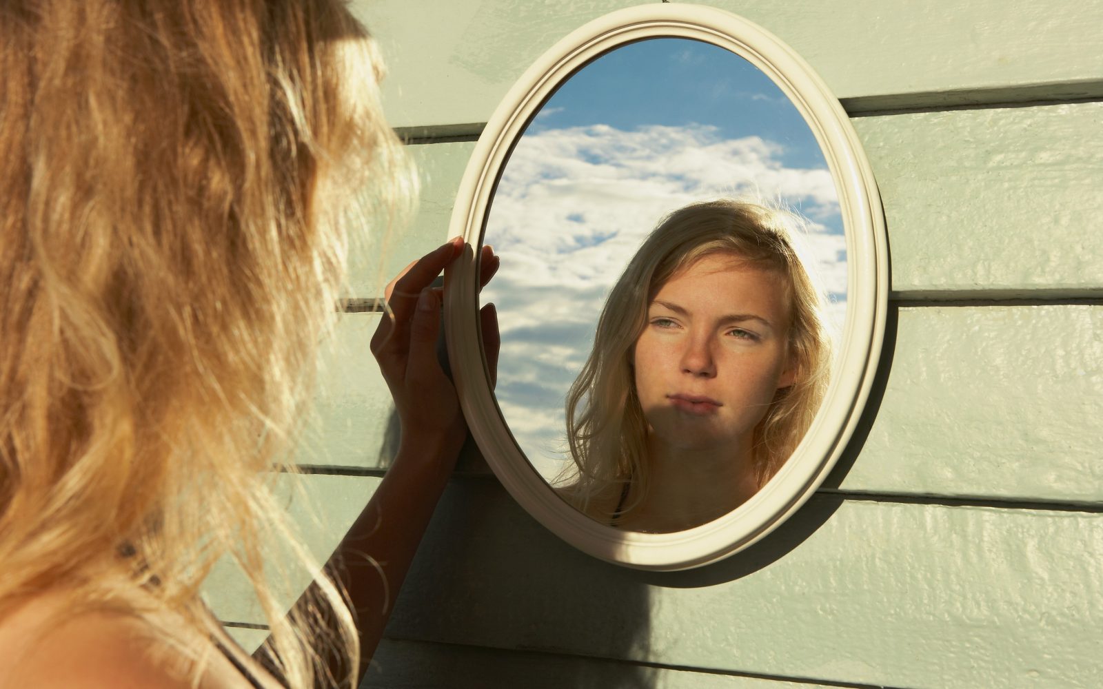 Mlada ženska se gleda v ogledalo