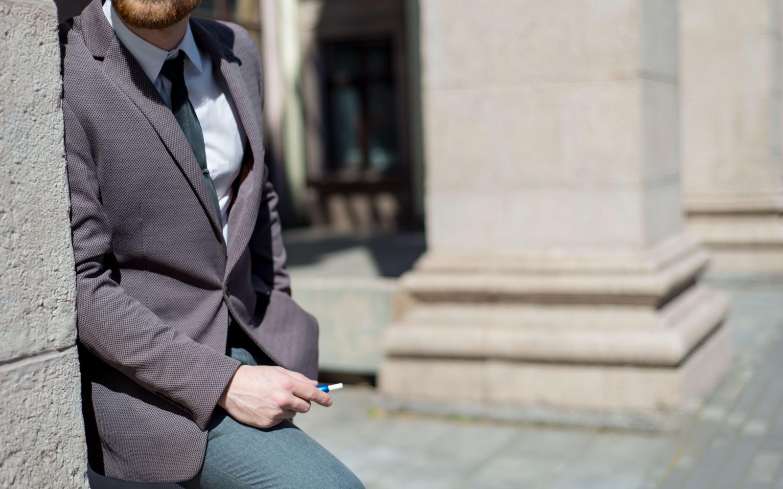 Moški z brado zunaj kadi ogrevan tobačni izdelek, iqos