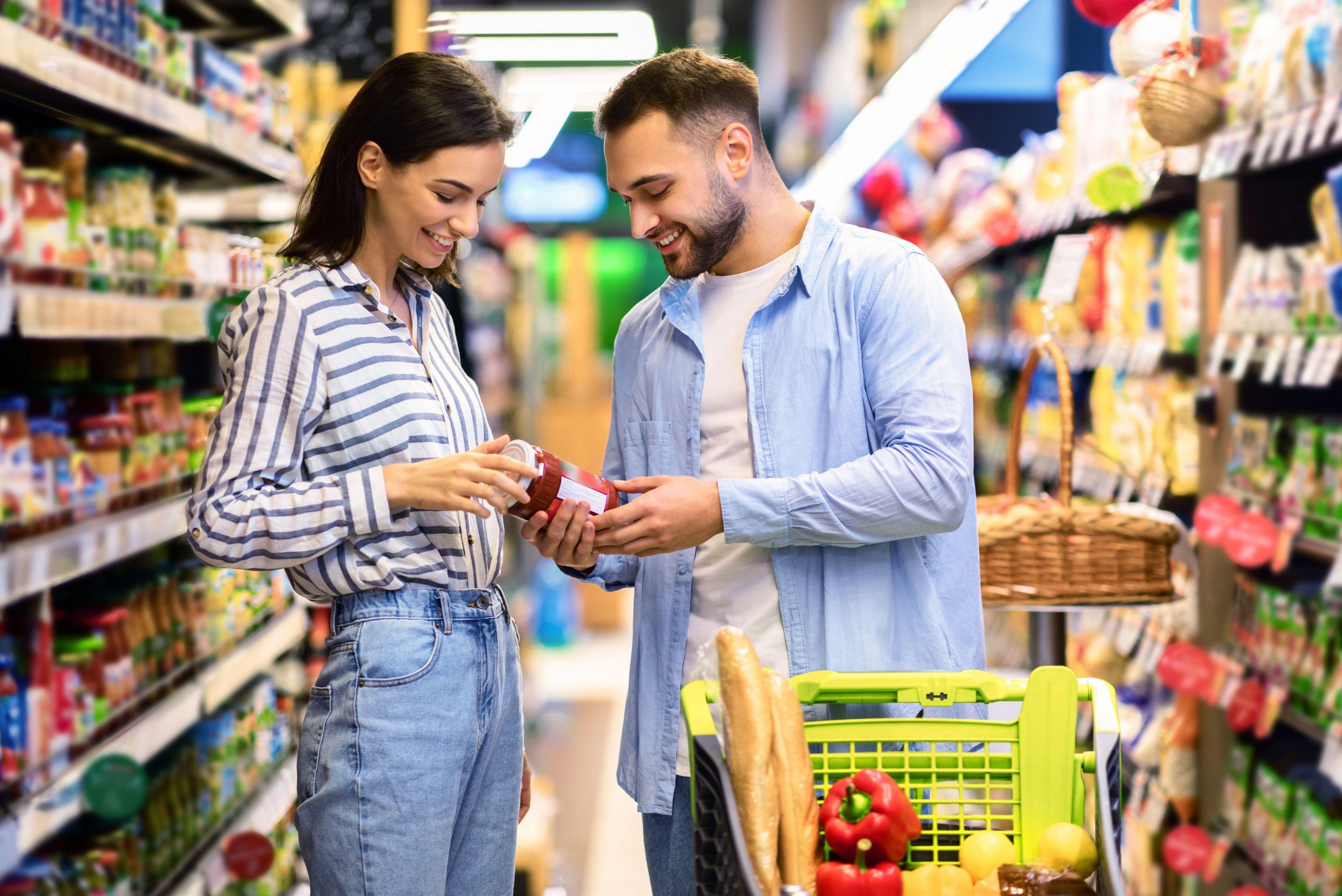 Par v trgovini pozorno pregleduje etiketo in certifikate ekološkega izdelka, preden se odloči za nakup živila.