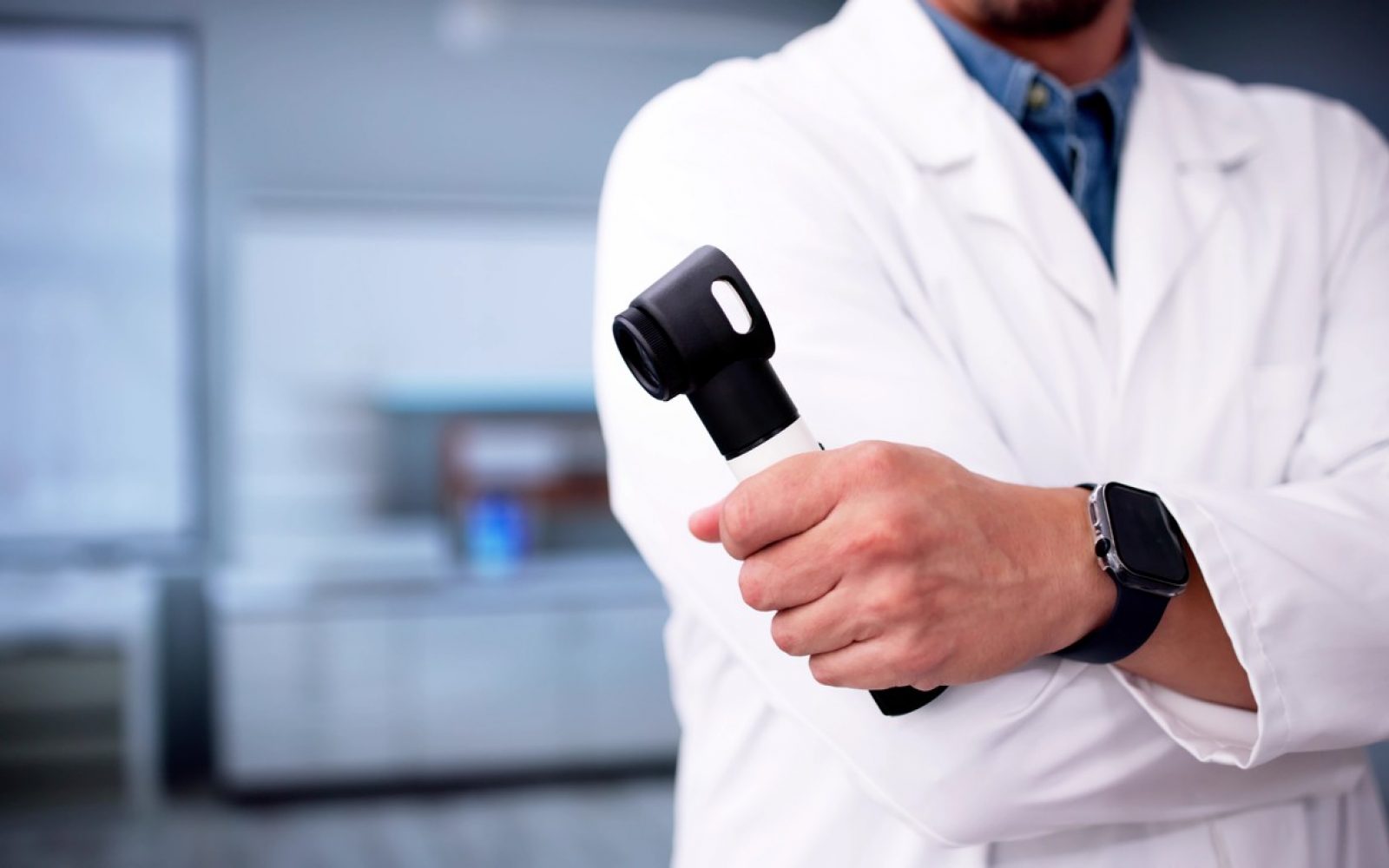 Dermatolog s dermatoskopom opozarja na nevarnosti sončnih opeklin in kožnega raka