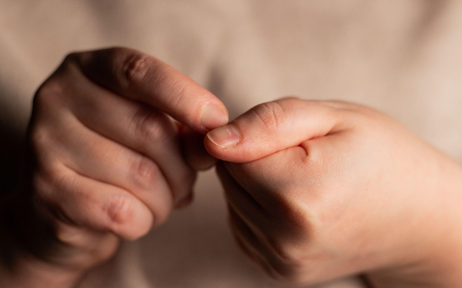 Nevtralna podoba rok, ki ponazarja pregled nohtov. Članek pojasnjuje, kako spremembe na nohtih – od sprememb barve in oblike do teksture – lahko nakazujejo različna zdravstvena stanja, vključno z anemijo, boleznimi jeter, srca, pljuč ter glivičnimi okužbami.