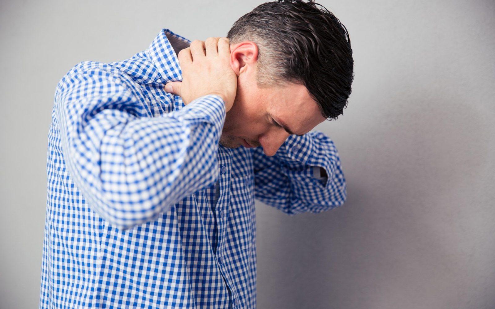 Moški z bolečinami v vratu si masira tilnik – napetost in pokanje vratu