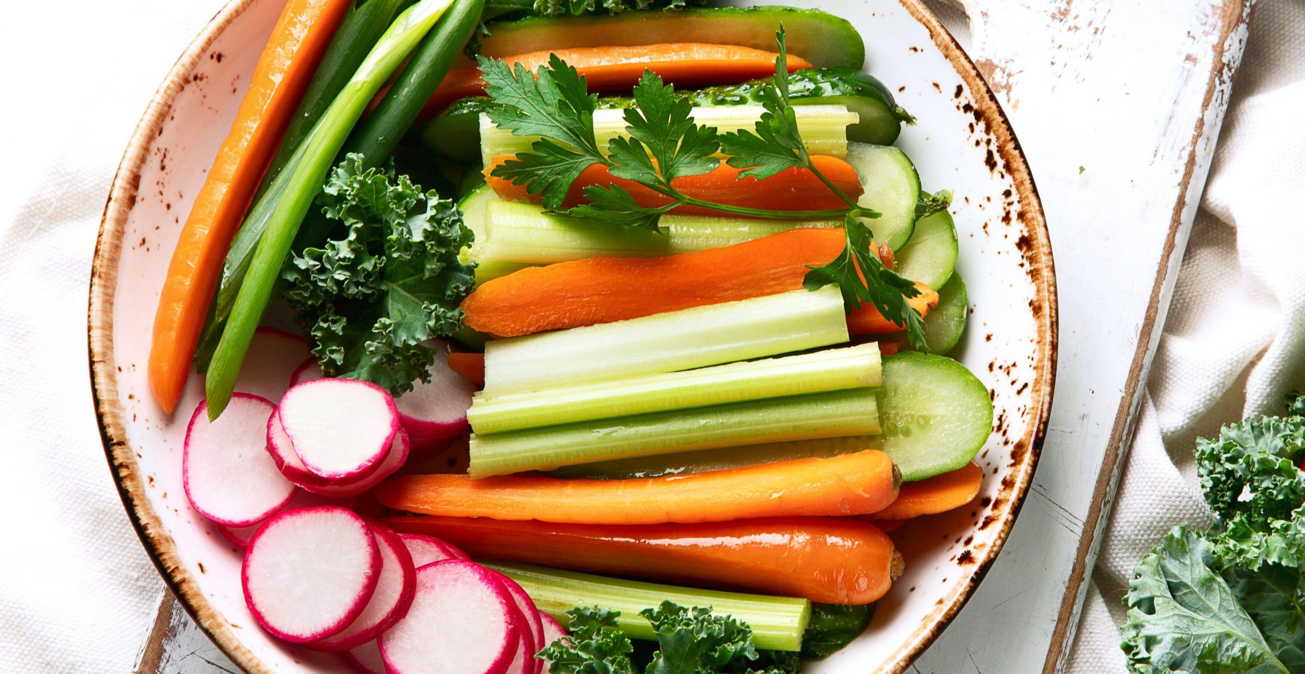 Na krožniku je narezana različna zelenjava, primer zdravega prgrizka