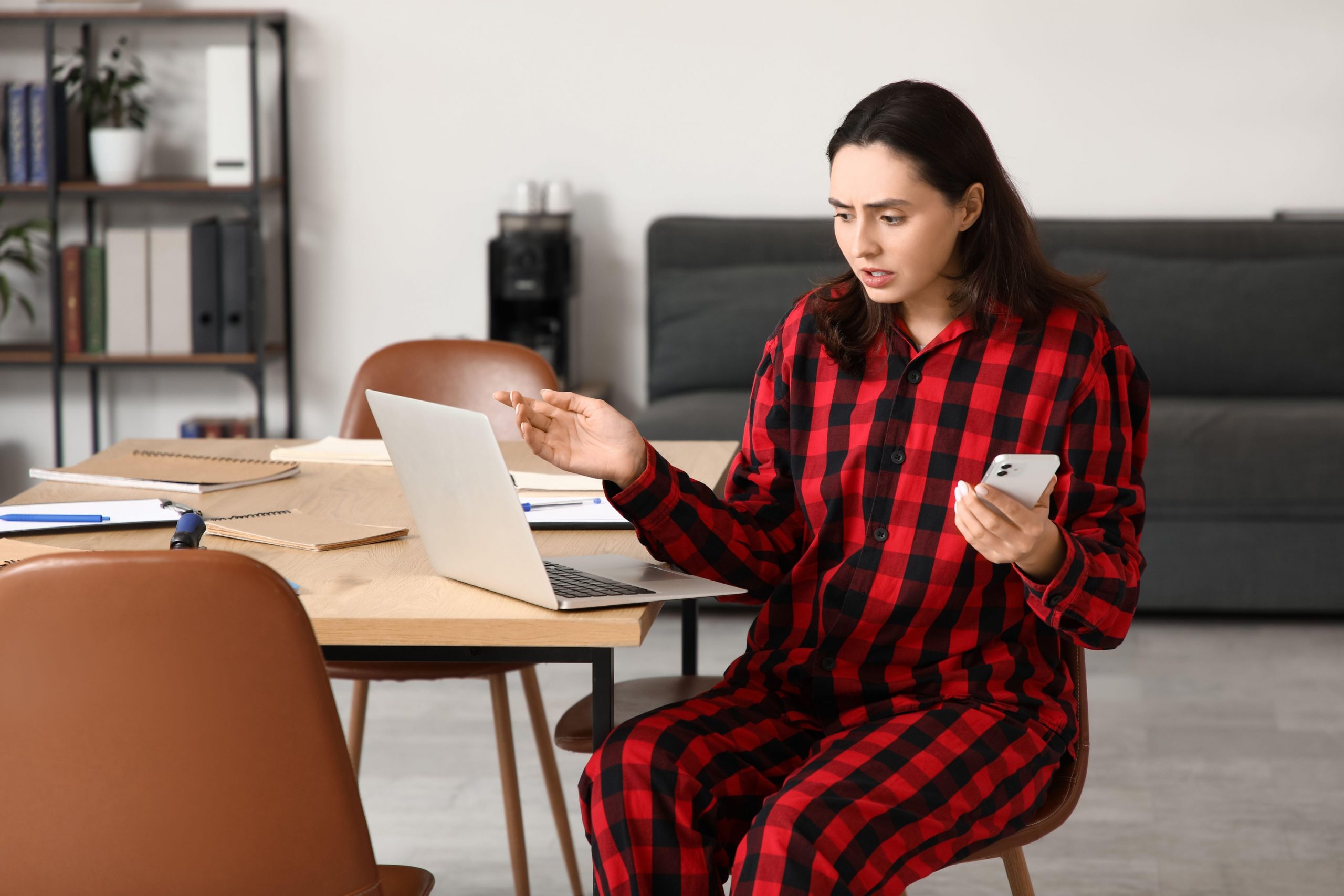 Poslovna ženska pod stresom dela od doma v pižami.