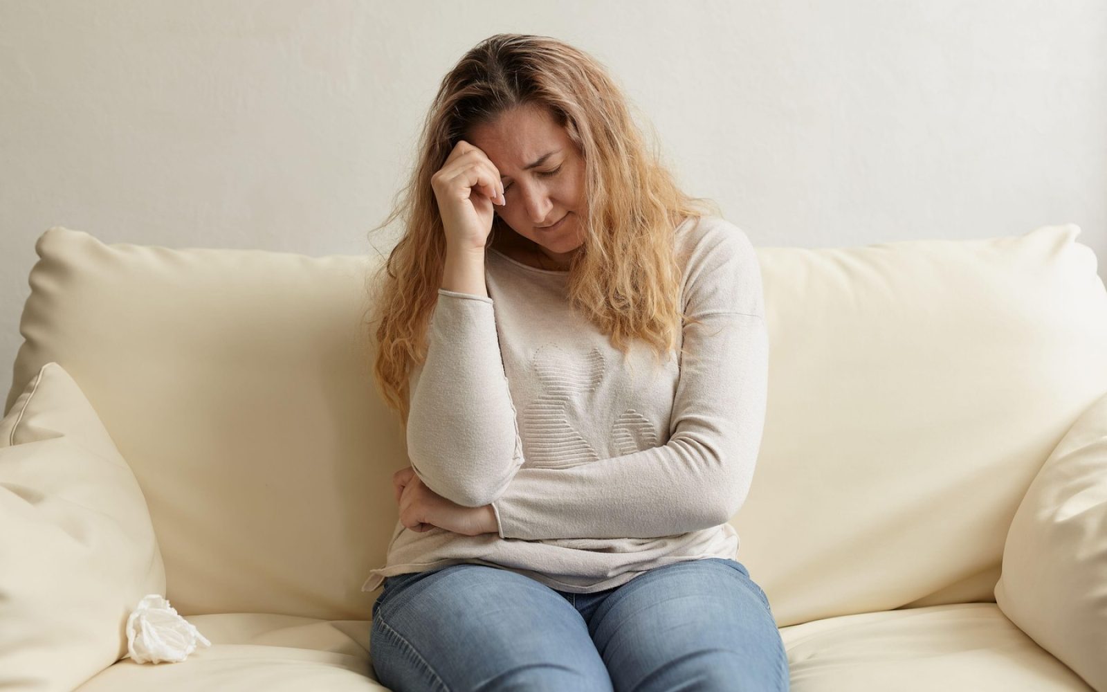 Ženska, ki se drži za glavo, in se sprašuje, ali so utrujenost in nihanje razpoloženja znaki staranja.