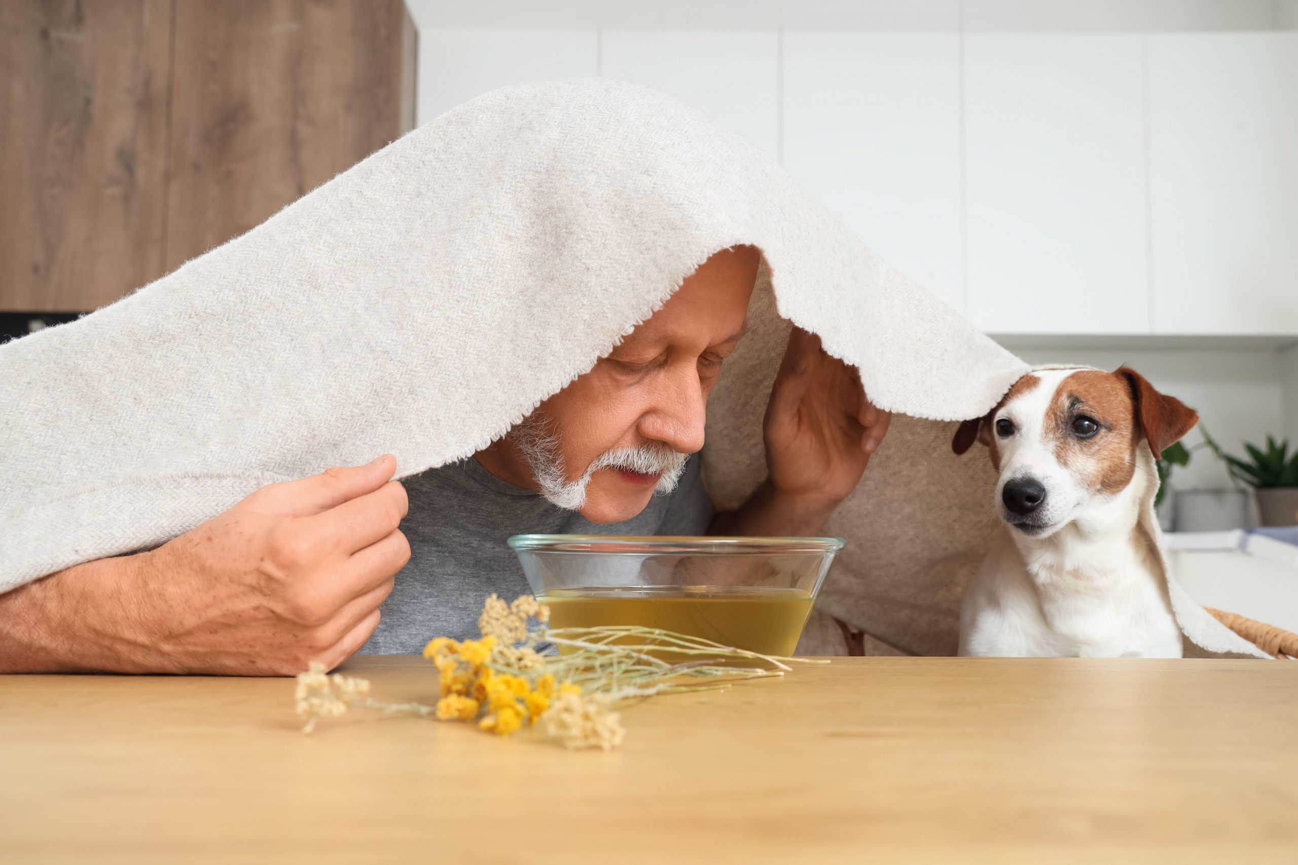 Starejši moški vdihava paro, da zmanjša simptome prehlada in kašelj - učinkovit naraven način.