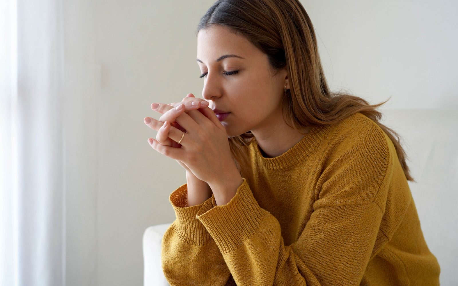 Dekle moli samo doma. Zaskrbljena ženska moli za moč in mir.