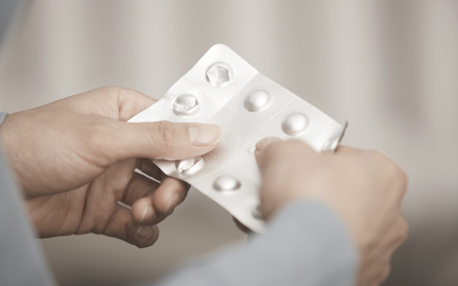 Ženska drži v rokah tablete, zdravila