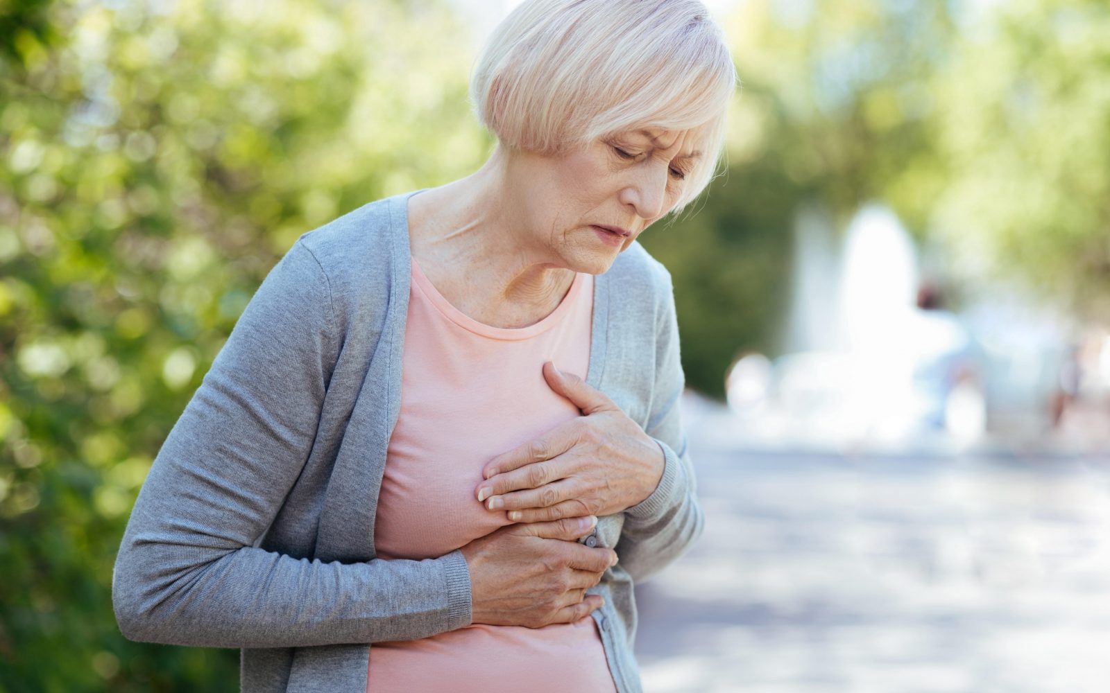 Starejša ženska se drži za prsa, bolečina v prsih