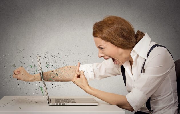 Jezna ženska kaže sredinca, z drugo roko je razbila računalnik