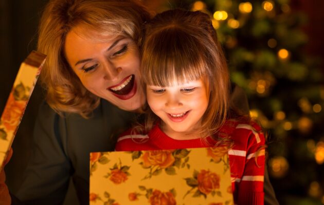 Mati in hči, hči odpira praznično darilo