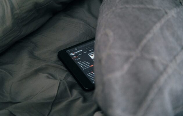 na postelji pod kovtrom je skrit telefon, na katerem je odprta pornografska stran