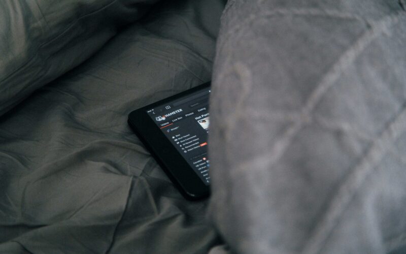 na postelji pod kovtrom je skrit telefon, na katerem je odprta pornografska stran