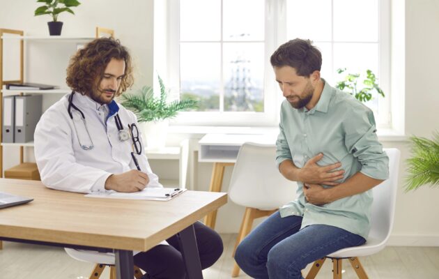 Moški v srednjih letih je pri zdravniku na pregledu, boli ga trebuh