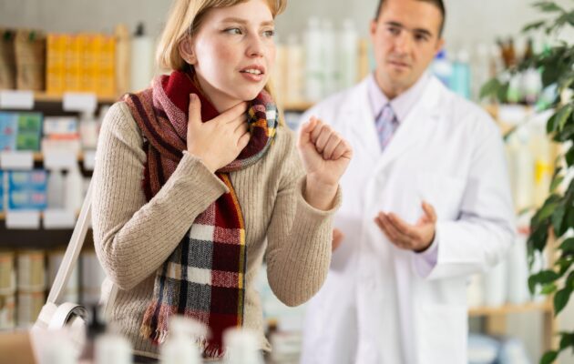 Ženska s kašljem v lekarni.
