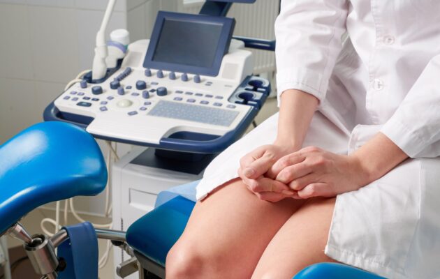 Ženska sedi in čaka na ginekološki pregled. Je živčna, saj stiska dlani