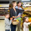 Družina - mati, oče, sin in hči - nakupujejo sadje in zelenjavo