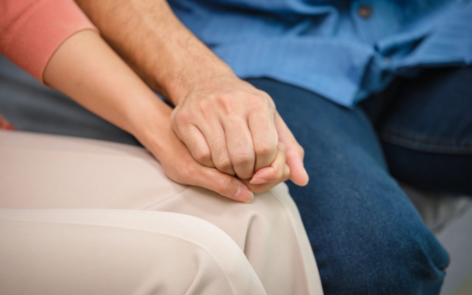 Dve osebi se držita za roke, simbolični prikaz empatije, podpore