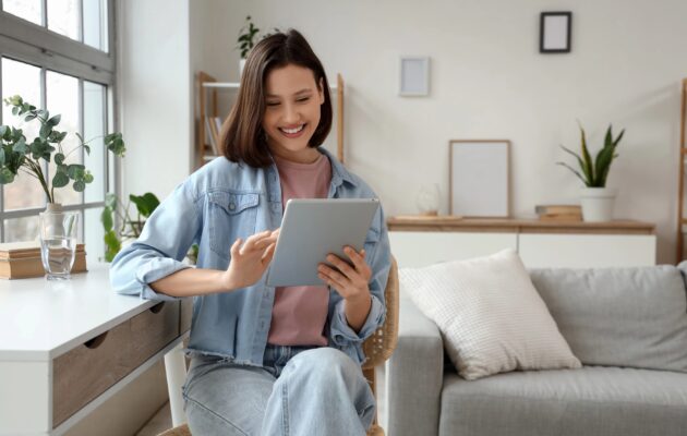 Deklica ima v rokah tablični računalnik in se smeji