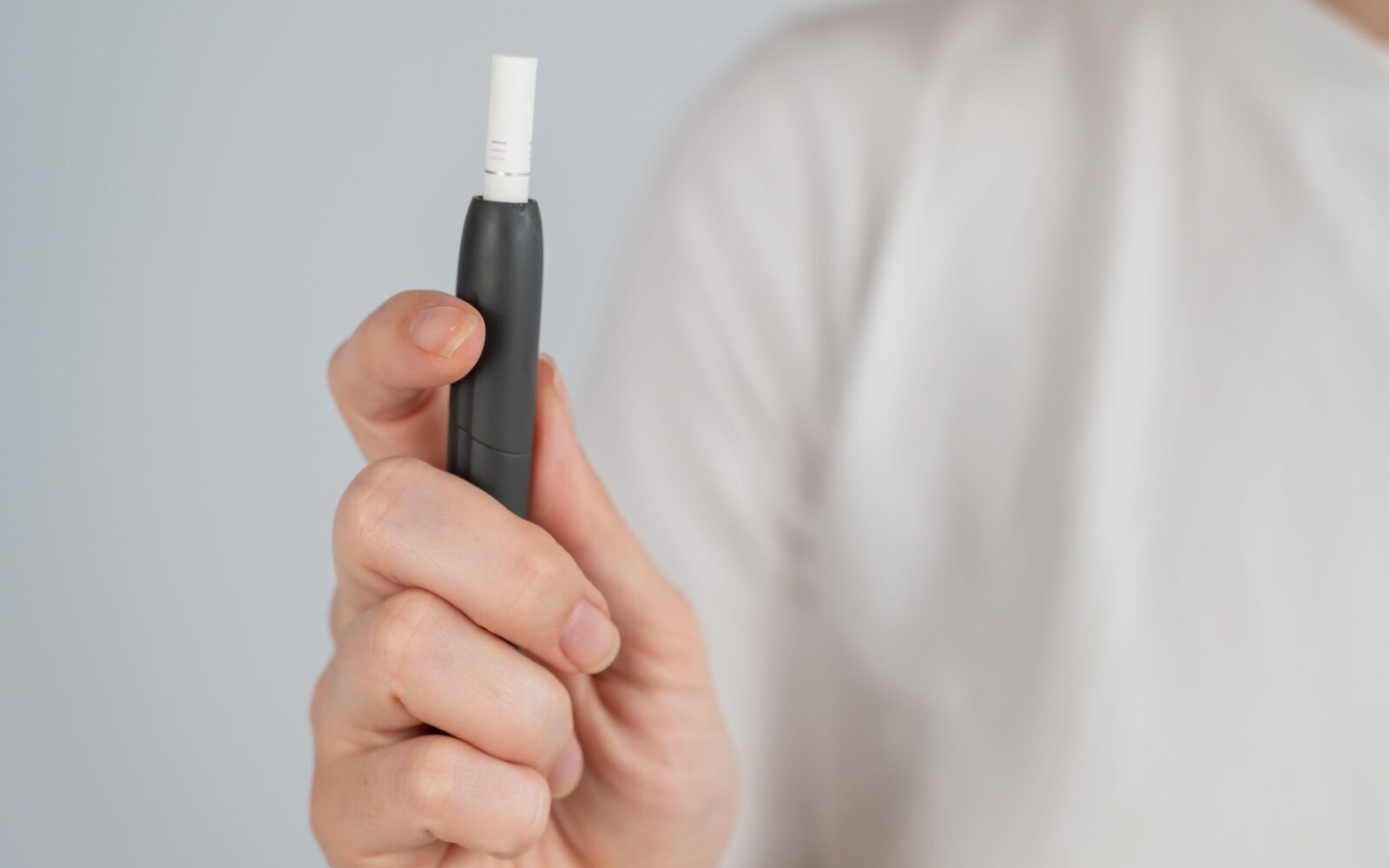 nekdo v rokah drži sistem za segrevanje tobaka