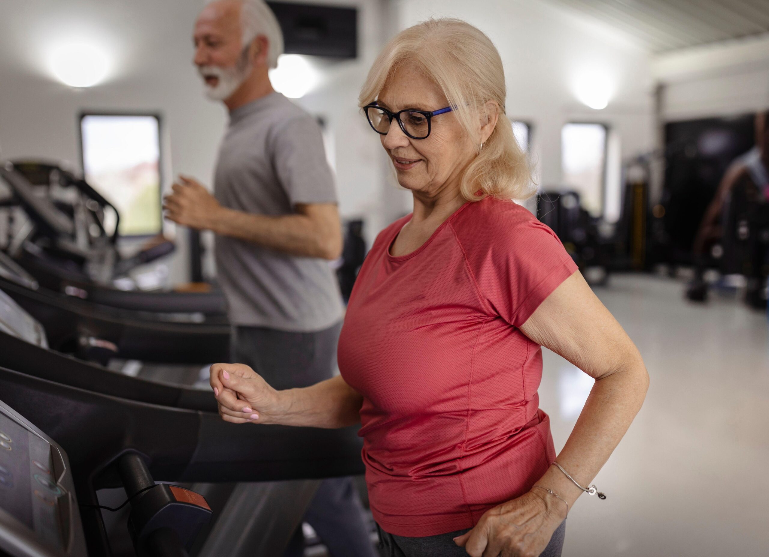 Starejši par telovadi v fitnesu