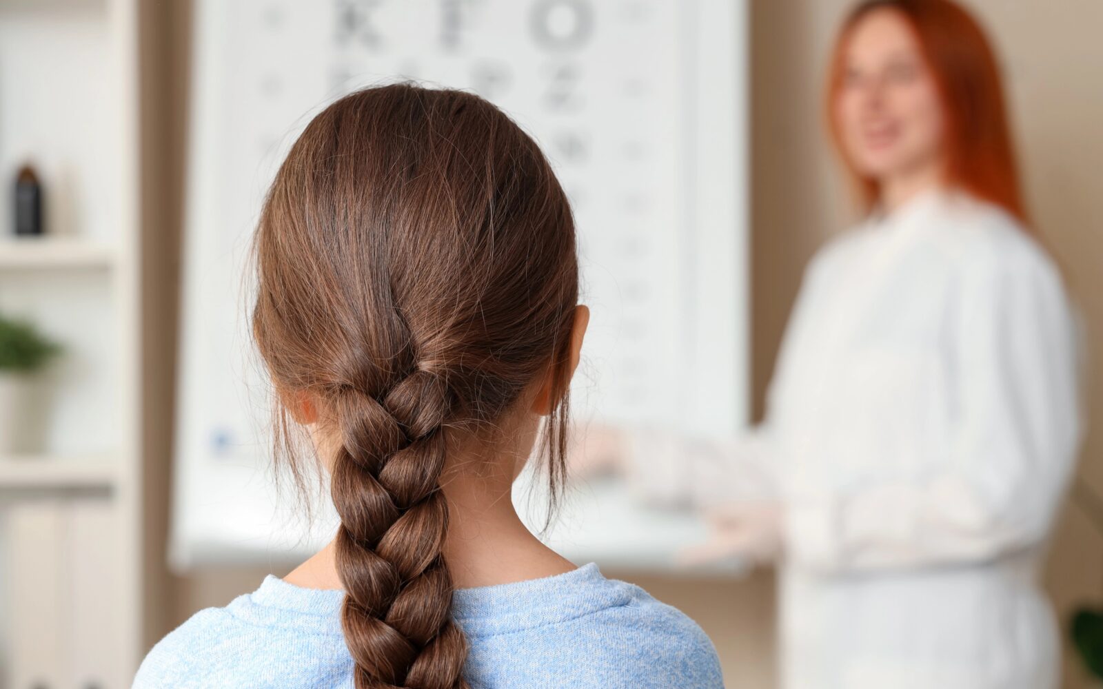 Deklica s spleteno kito je na pregledu oči pri oftalomologinji