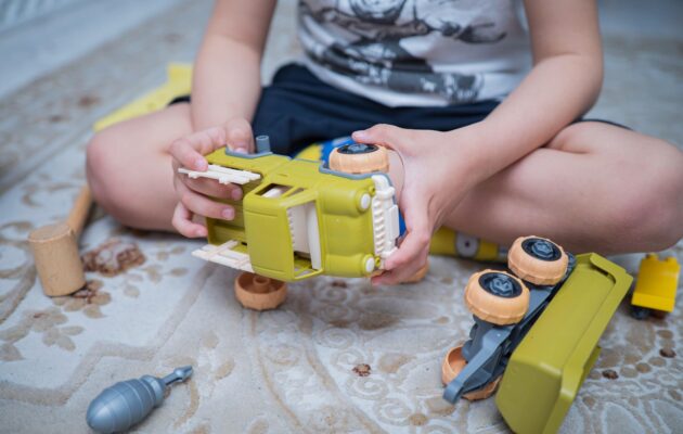 Fantek z avtistično motnjo se igra z avtomobilom