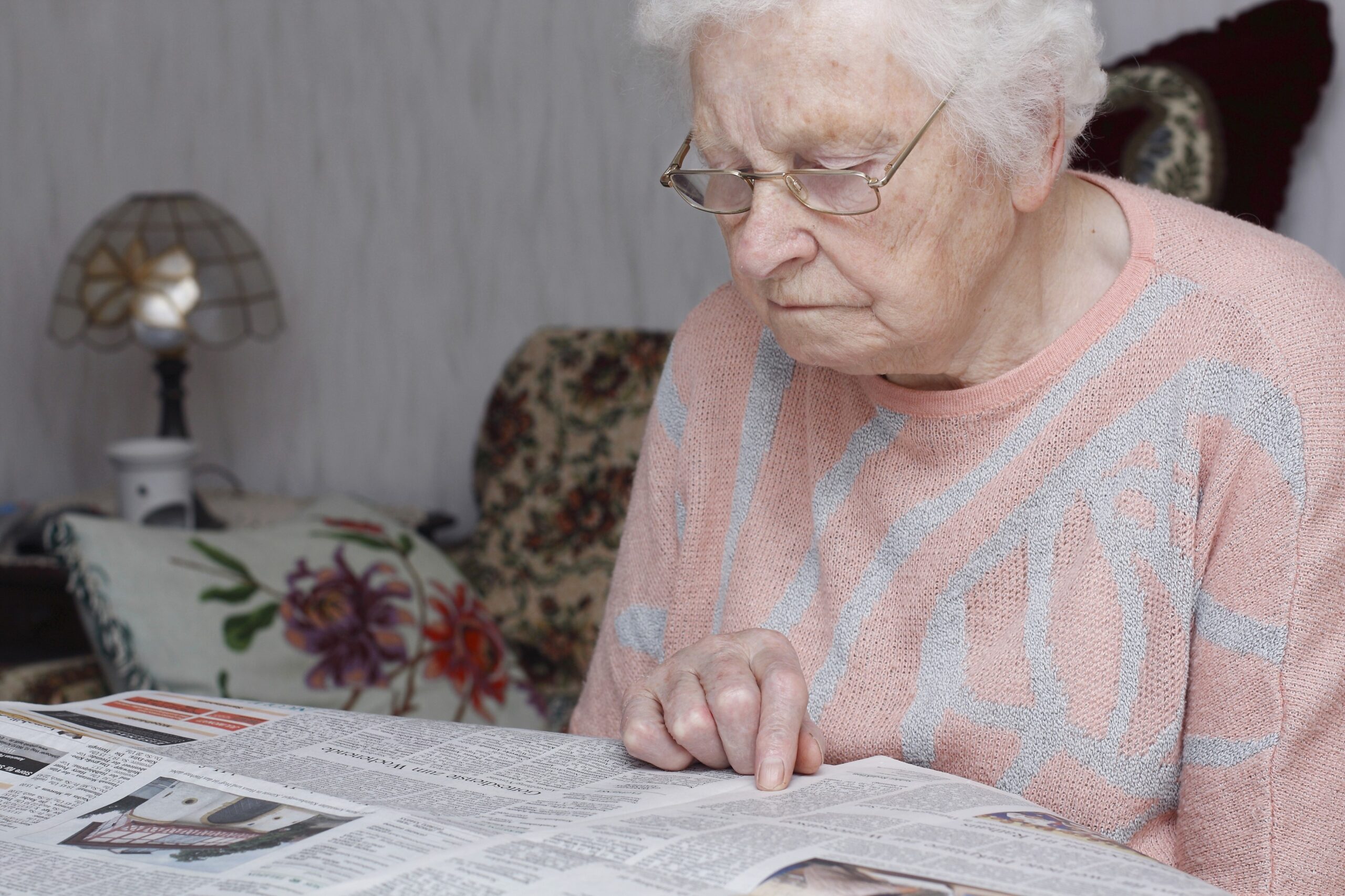 Starejša ženska bere časopis