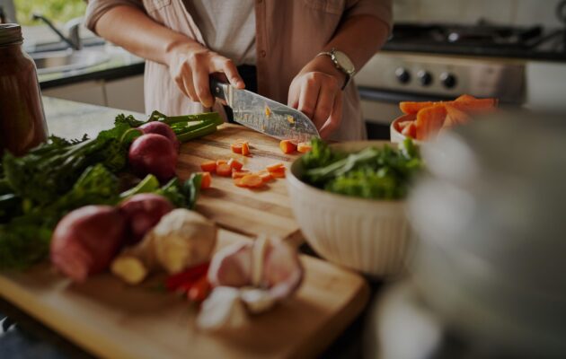 Ženska v kuhinji pripravlja zdrav obrok - živila, bogata s hranili, v podporo imunskemu sistemu.