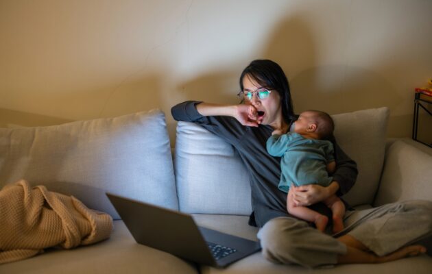 mama v naročju z dojenčkom, ki ne more spati, zato tudi ona ne spi in gleda v zaslon računalnika