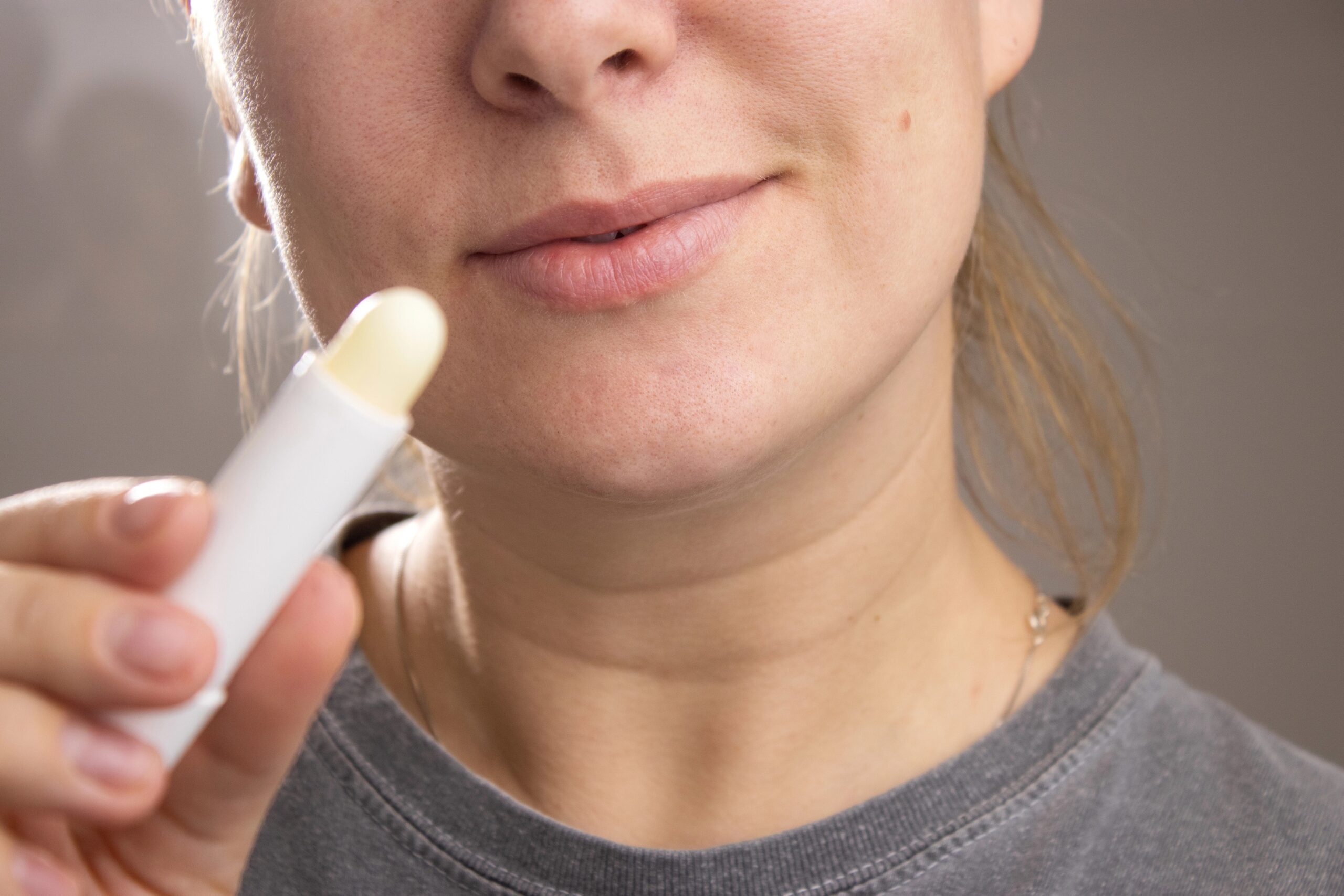 Ženska si bo z negovalnim izdelkom za nego ustnic namazala ustnice