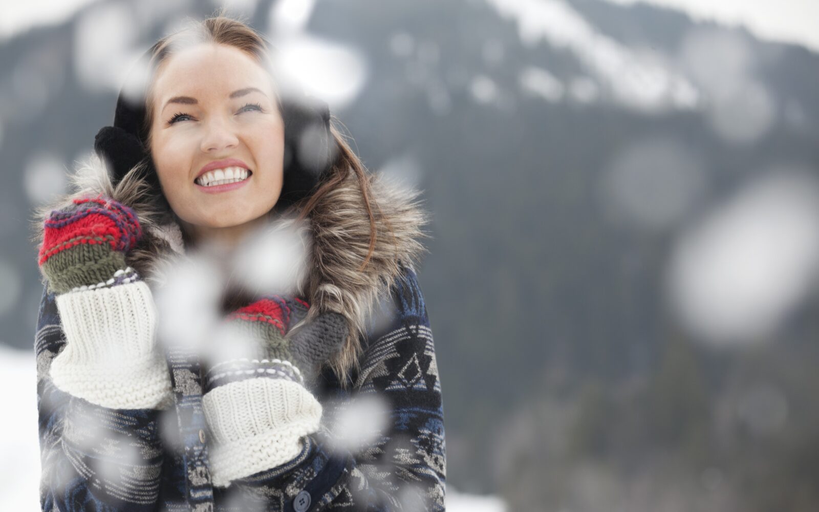 Zdrava, vesela ženska v zimskih oblačilih na snegu