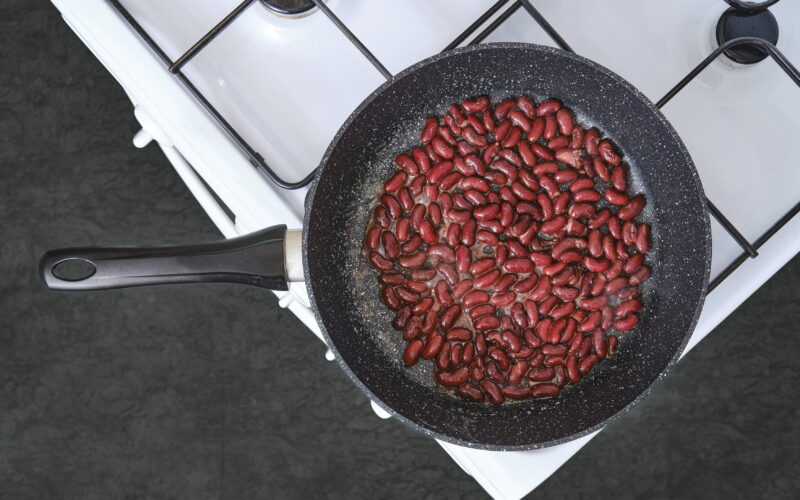 Fižol, ki se kuha v ponvi na štedilniku – pravilna priprava stročnic za zmanjšanje lektinov in tveganja za zdravje