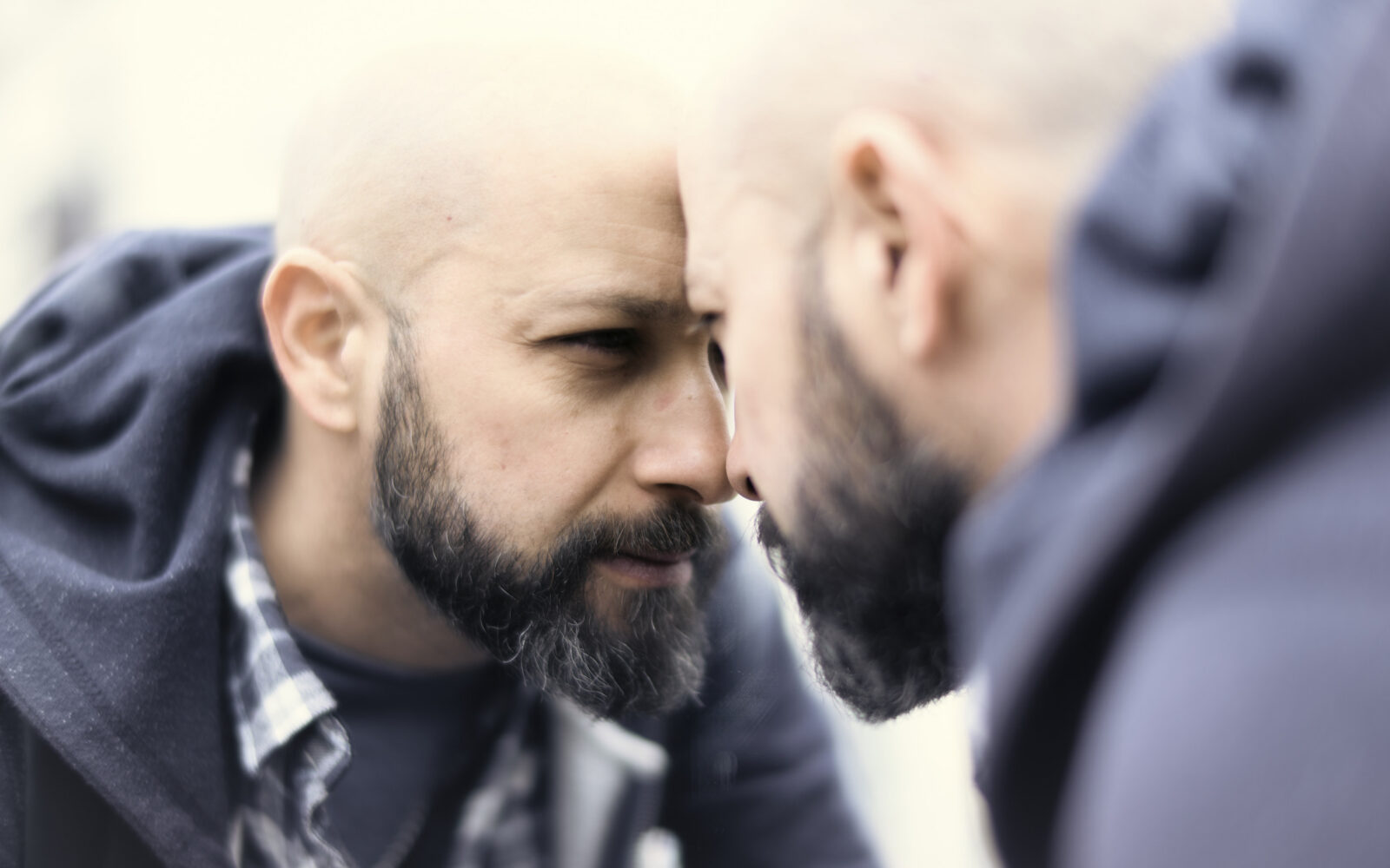 Moški se gleda v ogledalo in obžaluje svoje odločitve, kar je pripeljalo do krize srednjih let